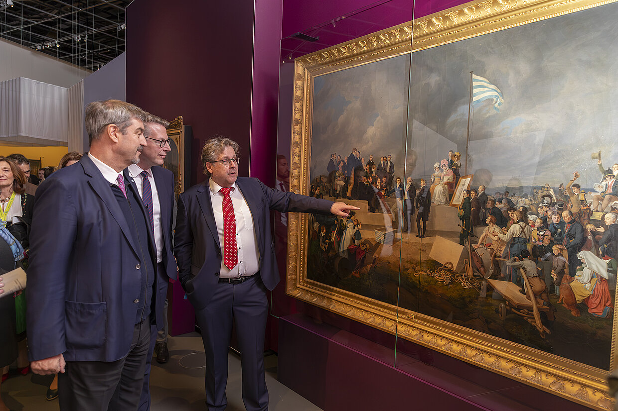 Ministerpräsident Dr. Markus Söder, MdL, Markus Blume, Staatsminister für Wissenschaft und Kunst und Direktor Dr. Richard Loibl betrachten das Gemälde „Die Grundsteinlegung der Gaibacher Konstitutionssäule“ von Peter von Hess. © HdBG| Foto: www.altrofoto.de

