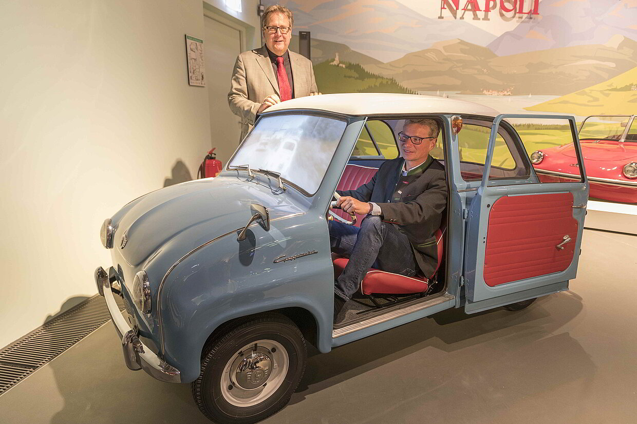 Die bayerischen Automobilikonen der 1950er- und 1960er-Jahre bilden im neuen Museum in Regensburg einen illustren Korso Richtung Brenner. Angeführt wird die Autostraße von einem Goggomobil der Firma Glas aus Niederbayern. Wie es Kunstminister Bernd Sibler vormacht, können die Besucherinnen und Besucher persönlich einsteigen und sich virtuell auf die Fahrt über den Brenner in den 1950er-Jahren begeben.