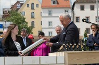 Staatsminister Dr. Ludwig Spaenle übergibt der Zeitkapsel für den Museumgrundstein eine Kopie der ersten Seite der handschriftlichen bayerischen Chronik von Aventin aus dem Jahr 1519. 