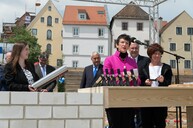 Inge Aures, Vizepräsidenten des Bayerischen Landtags, übergibt der Zeitkapsel für den Museumsgrundstein eine Bayerische Verfassungsmedaille.